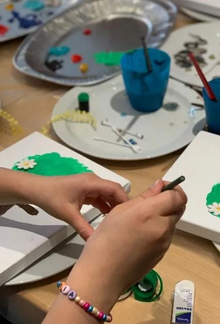 Minikonfirmand maler på et lærred