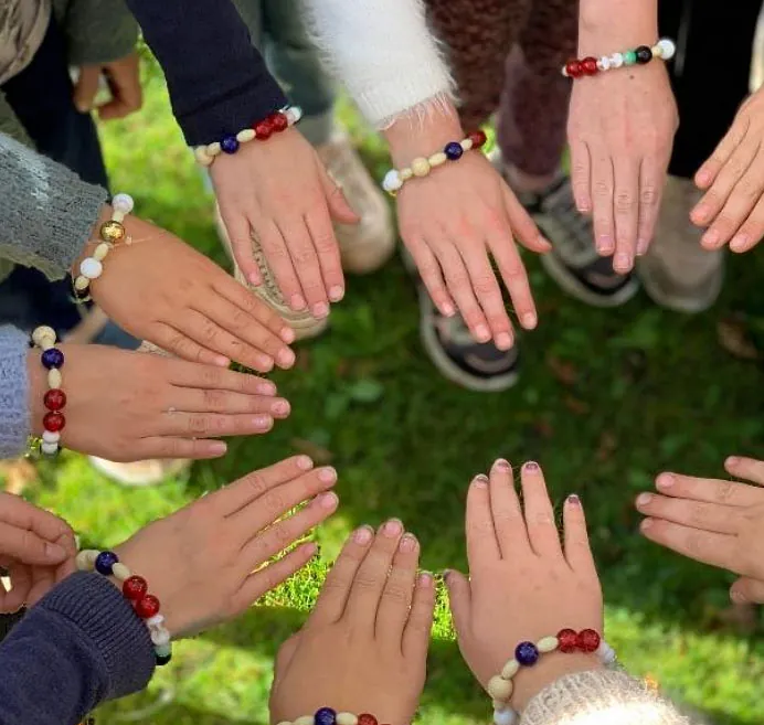 Minikonfirmander viser deres hjemmelavede armbånd frem