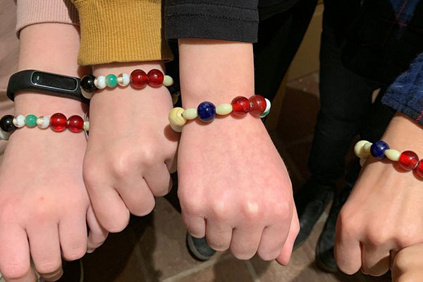 Minikonfirmander viser deres hjemmelavede armbånd frem